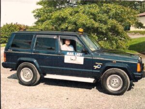 Rural letter carrier Carol Warfel driving her right-hand drive Cherokee