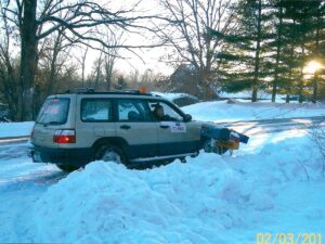 Rural letter carrier Dixie Ray driving her RHD Subaru Forester postal delivery vehicle in the snow