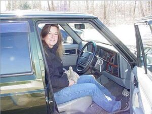 Rural letter carrier Ellen Graham in the drivers seat of her RHD Jeep Cherokee postal delivery vehicle