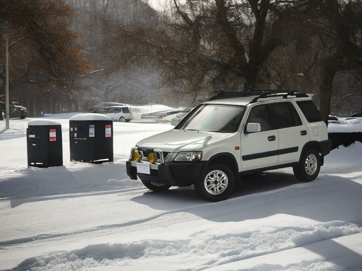 RHD Honda CR-V left front view on snowy road.