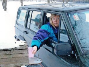 Rural mail carrier Irene Leggett delivering mail from her RHD Jeep Cherokee