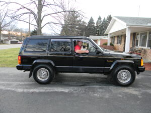 Rural letter carrier Jay Crawford driving his RHD Cherokee postal delivery vehicle.