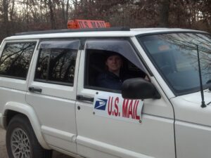 Rural letter carrier Jennifer Nielsen with her RHD Jeep Cherokee postal delivery vehicle