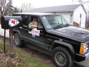 Rural letter carrier Kirby Ricketts delivering mail from the right side of his RHD Jeep Cherokee