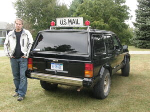 Rural letter carrier Nathan Smith with his RHD Cherokee postal delivery vehicle