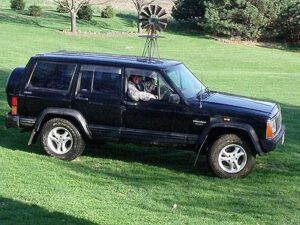 Rural letter carrier Steve Hughes driving his RHD postal delivery Jeep Cherokee