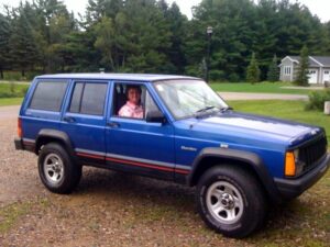 Rural letter carrier Sue Tango driving her RHD Jeep Cherokee