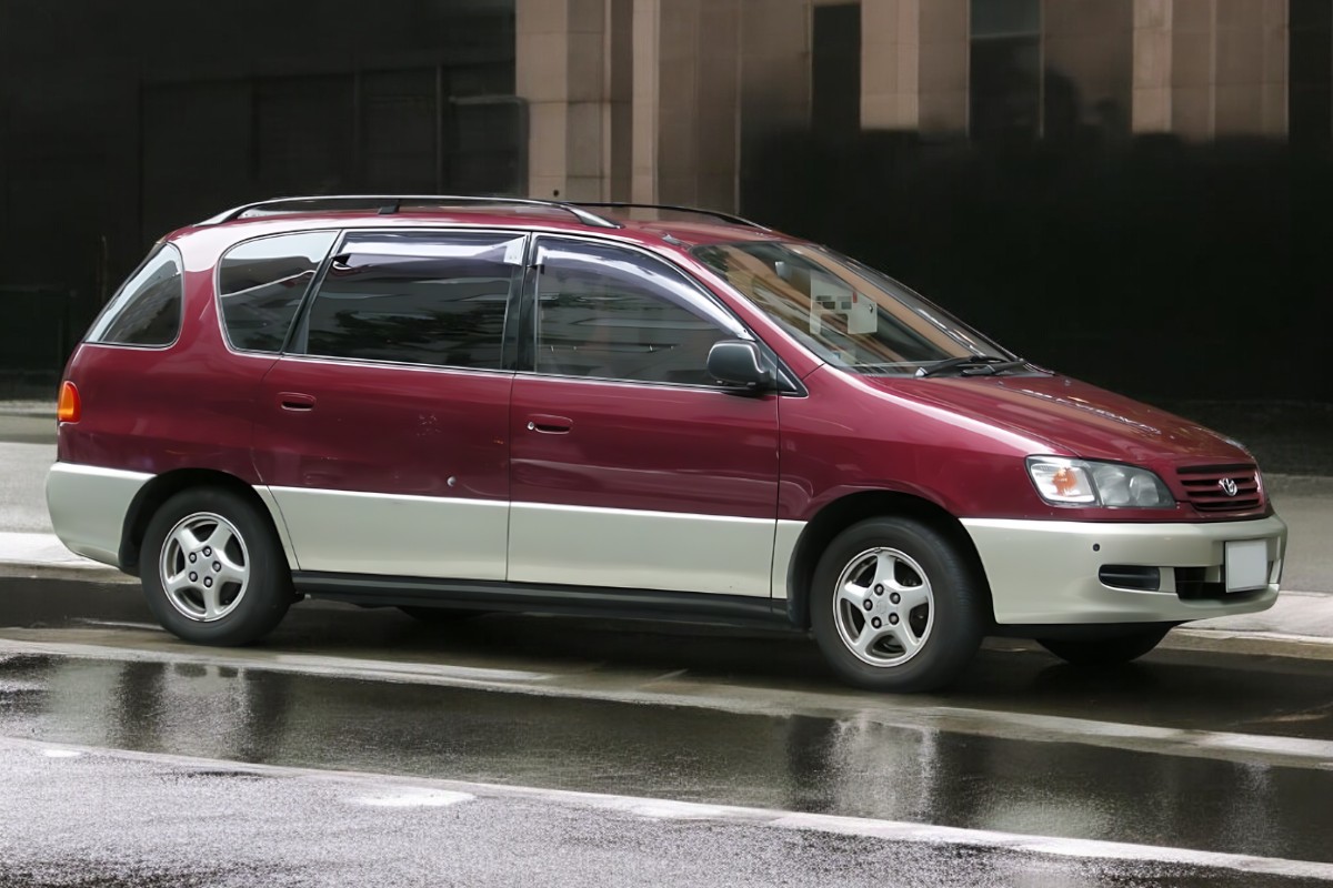 RHD Toyota Ipsum in red from right side parked on a street